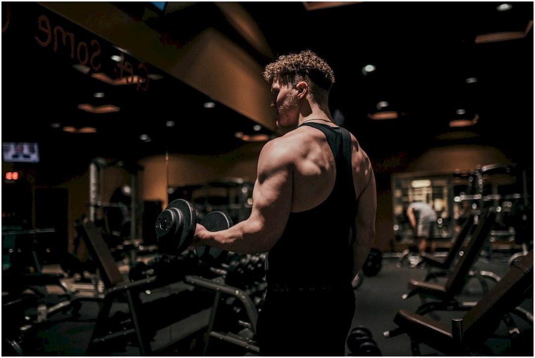 a man holding a dumbbell in a gym