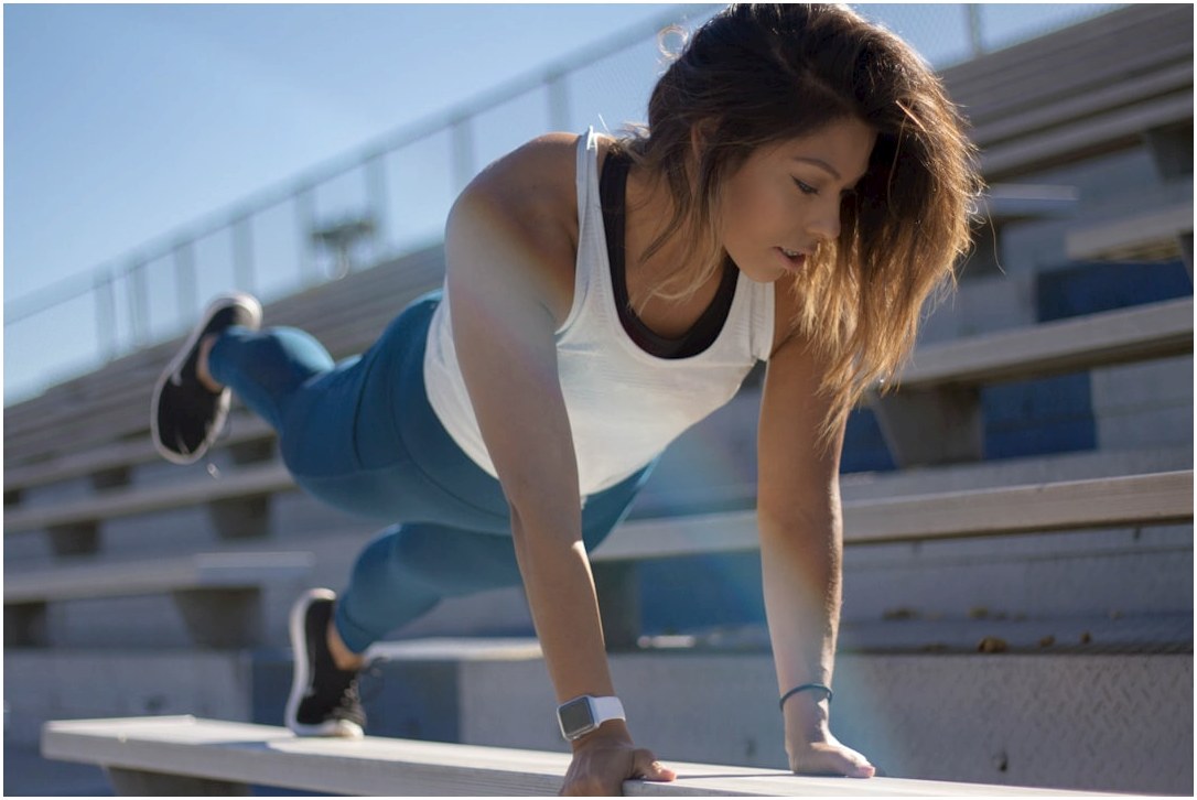 selective focus photography of woman doing planking on bench