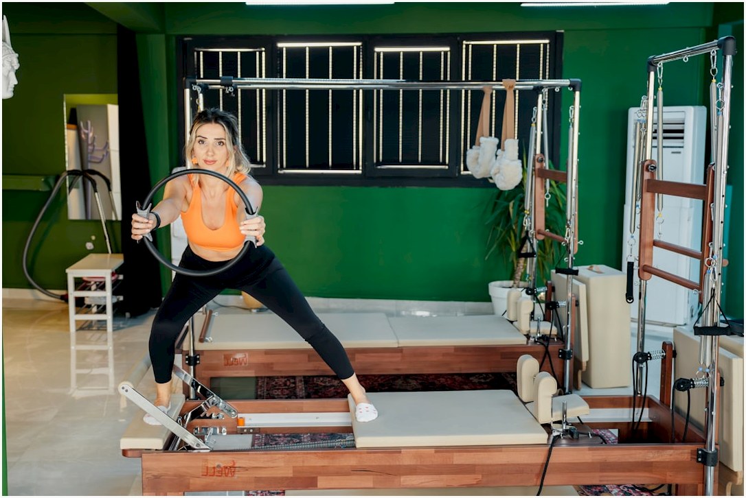 A woman is doing pilates with a ring.