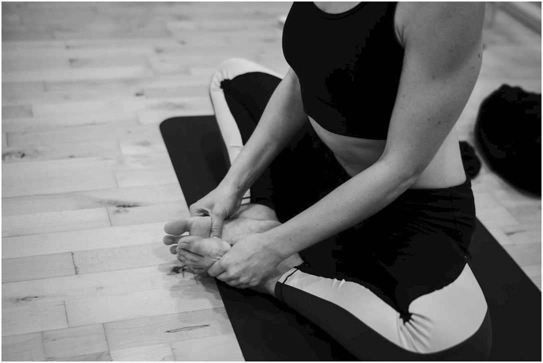 A woman sitting on a yoga mat with her legs crossed