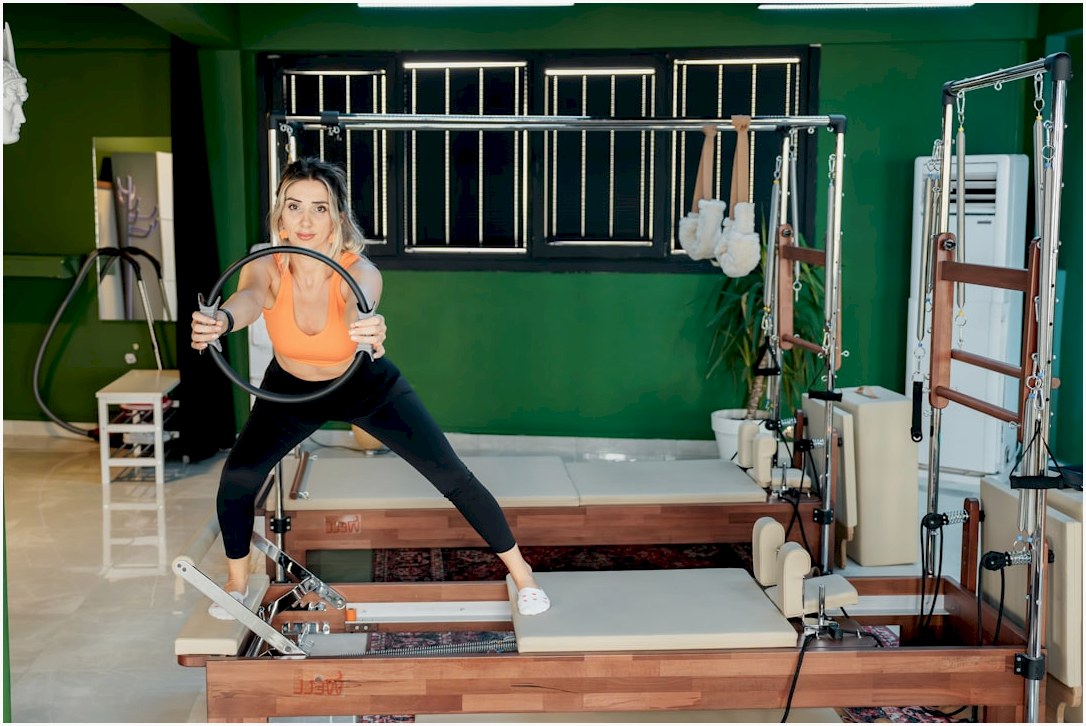 A woman is doing pilates with a ring.