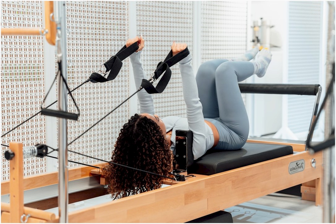 a woman is doing exercises on a rowing machine