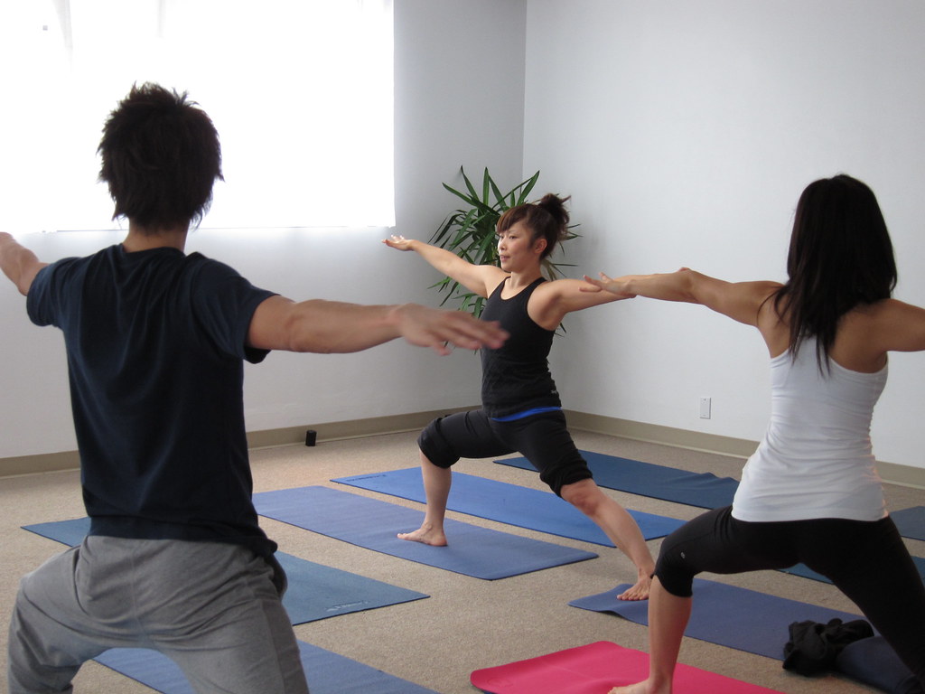 Aula em grupo em tapetes de exercício, mostrando o espaço necessário entre os colchonetes.