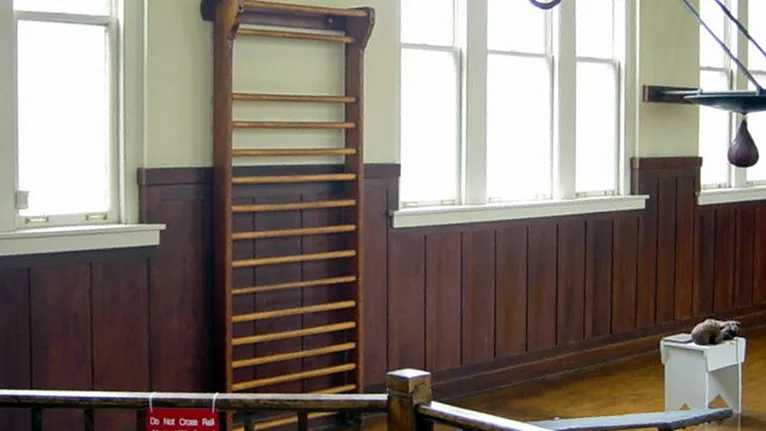 Barra de parede de madeira instalada em uma sala de exercícios, usada como ilustração de equipamento fixado à parede
