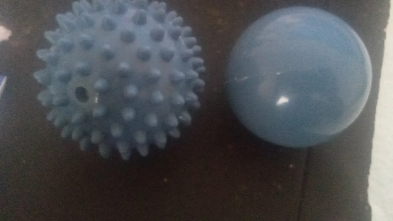 Duas bolas de massagem, uma com pontas e outra lisa, usadas como acessórios de Pilates