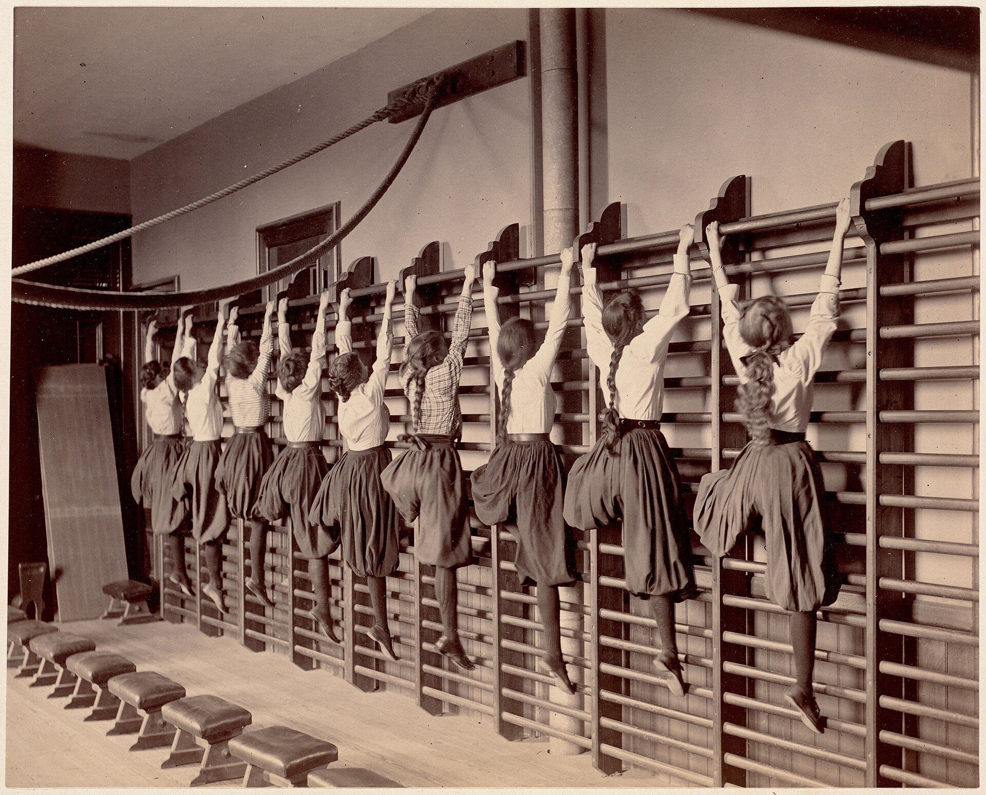 Espaldar de parede com barras horizontais em uma aula histórica de exercícios; imagem ilustrativa do equipamento.