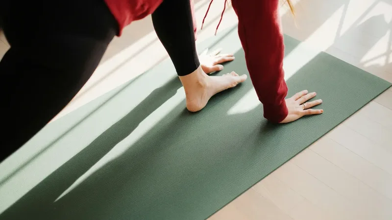 Pessoa praticando uma posição de Pilates sobre um tapete, com apoio das mãos e dos pés.