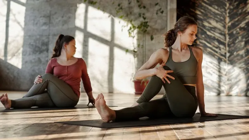 Duas pessoas praticam Pilates em colchonetes, com orientação e movimentos controlados.