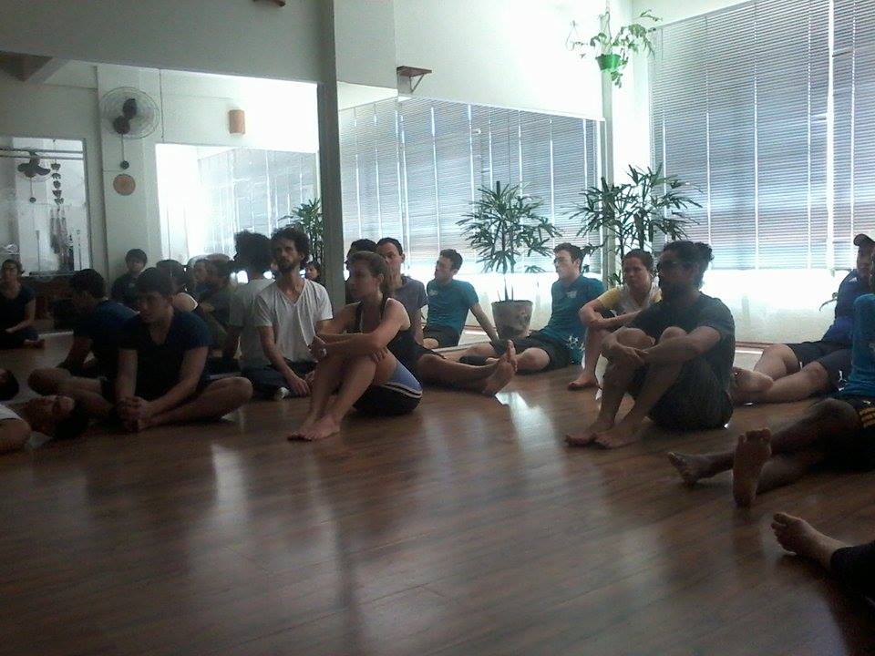 Turma praticando Pilates em colchonetes durante uma aula supervisionada