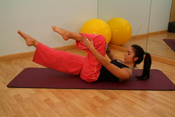 Instrutor conduz uma sessão de Pilates em grupo, imagem ilustrativa para prática com orientação e atenção ao equilíbrio
