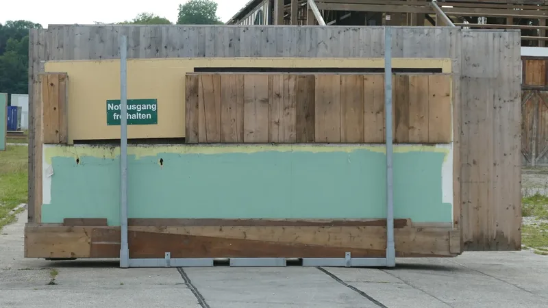 Placa verde de saída de emergência em uma estrutura, usada para ilustrar a sinalização e a rota de evacuação de um estúdio de Pilates