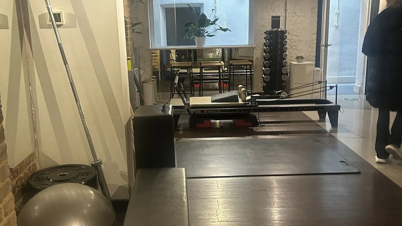 Reformer em uma sala de estúdio de Pilates, com equipamentos organizados para as aulas.