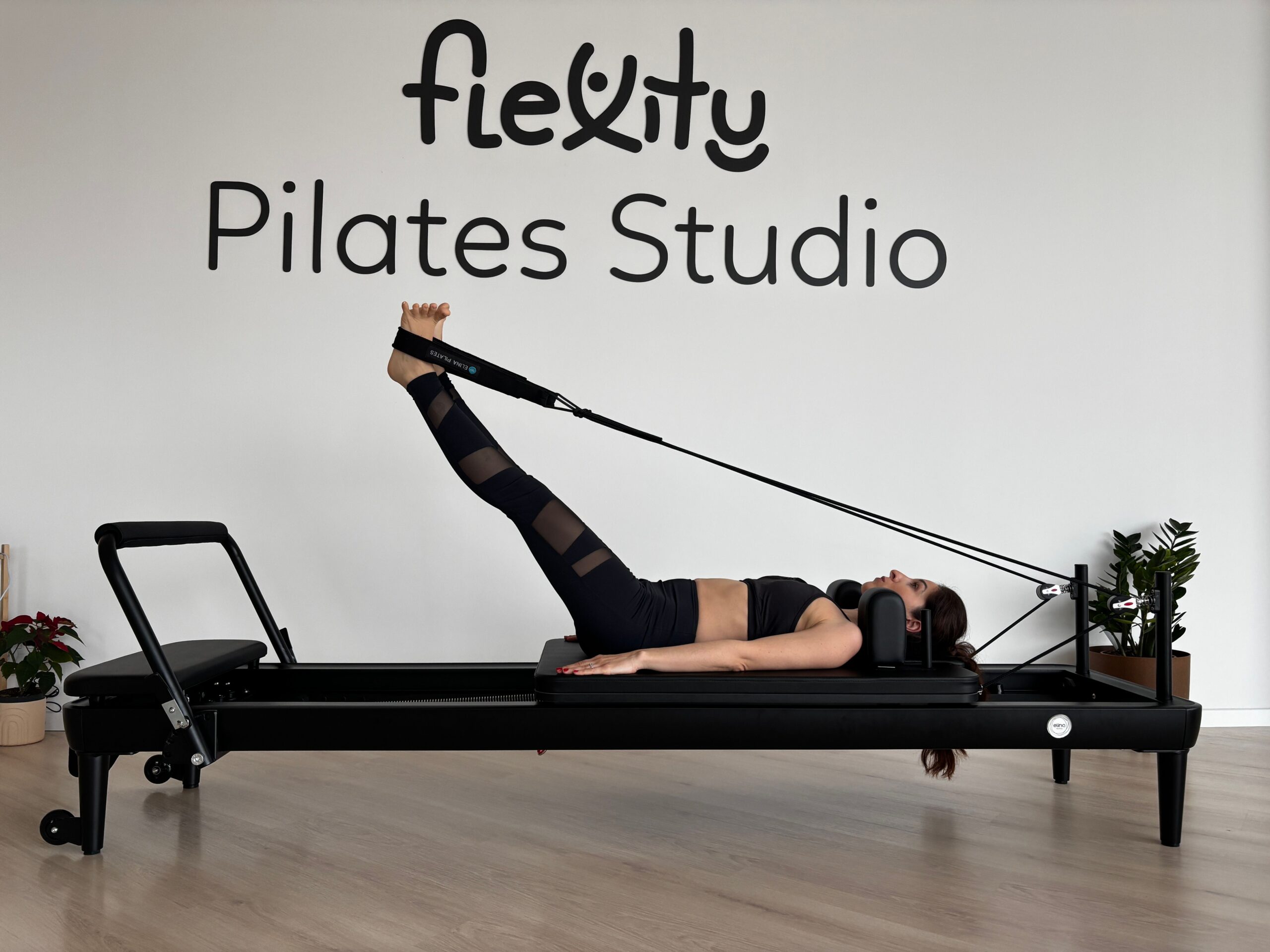 Pessoa praticando Pilates em um reformer em estúdio; imagem ilustrativa para escolha de equipamento.