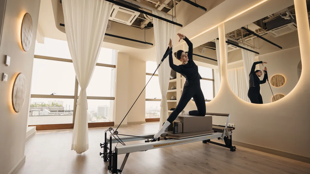 Pessoa praticando Pilates em um Reformer em um estúdio