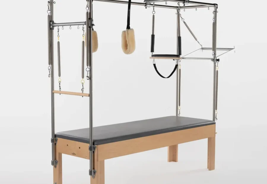 Cadillac ou Trapeze Table de Pilates com estrutura vertical, barras, alças e molas.