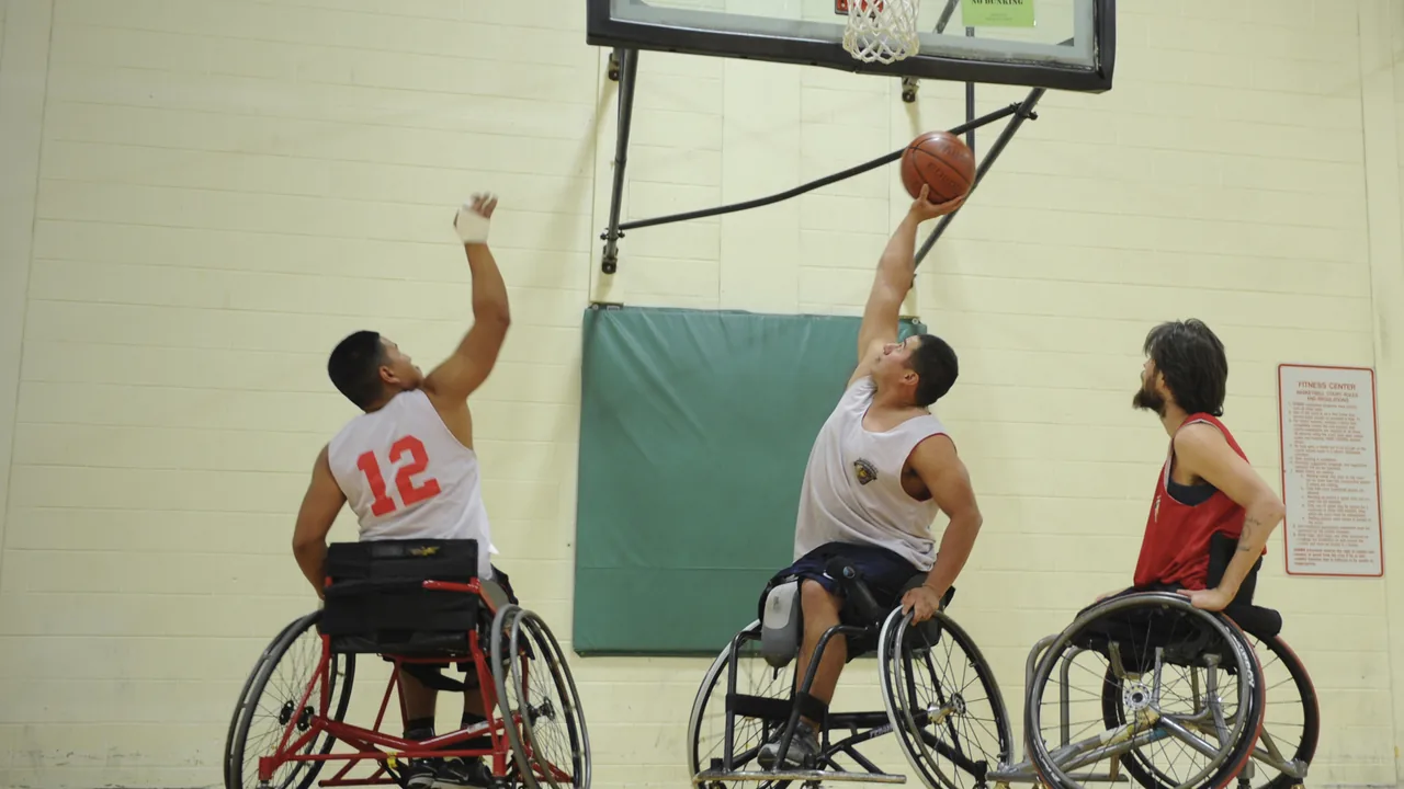Atletas em cadeiras de rodas praticam basquete em uma quadra