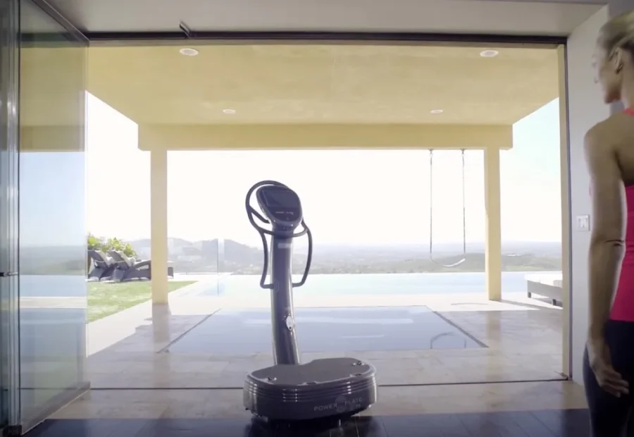 Plataforma vibratória preta em uma sala de exercícios