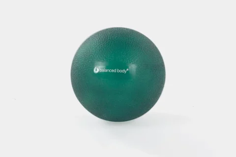 Bola pequena de Pilates verde sobre fundo claro