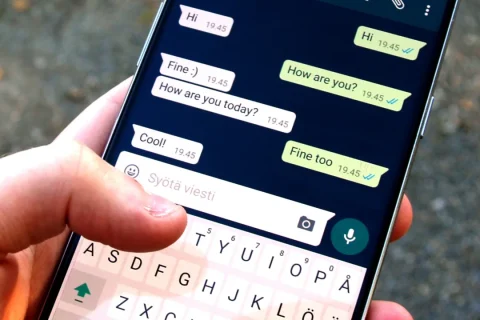 Pessoa segurando um celular com uma conversa aberta no WhatsApp