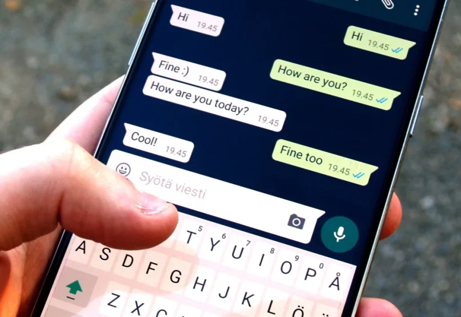 Pessoa segurando um celular com uma conversa aberta no WhatsApp