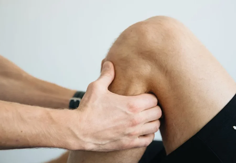 Fisioterapeuta avalia o joelho de uma pessoa durante uma sessão de reabilitação
