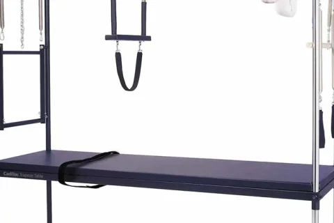 Cadillac de Pilates com mesa, estrutura vertical e acessórios visíveis