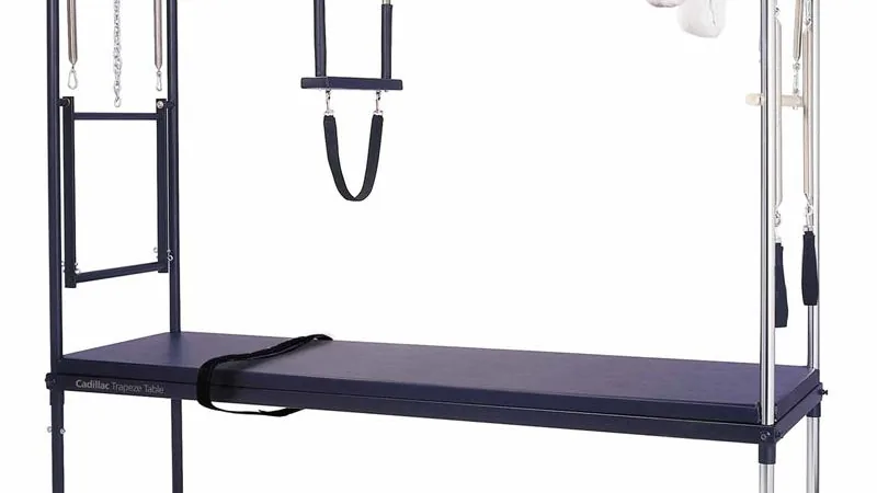 Cadillac de Pilates com mesa, estrutura vertical e acessórios visíveis