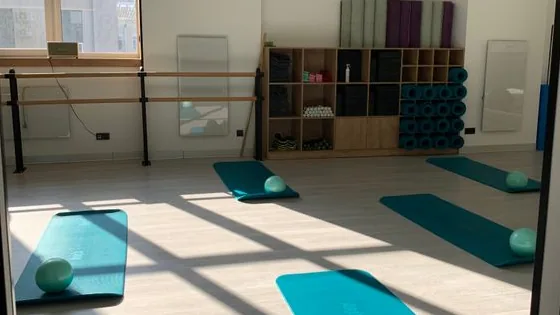Sala de Pilates iluminada com colchonetes e equipamentos