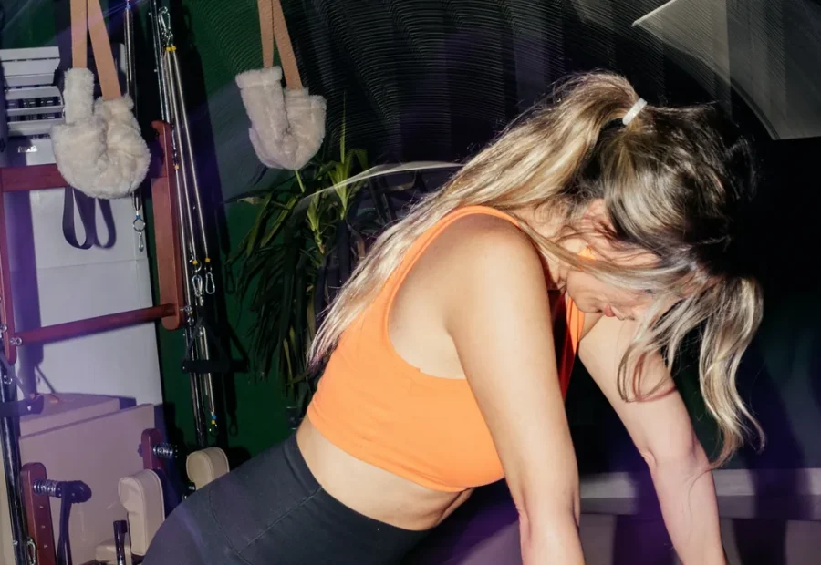 Pessoa em posição de apoio sobre um aparelho Reformer em um estúdio de Pilates
