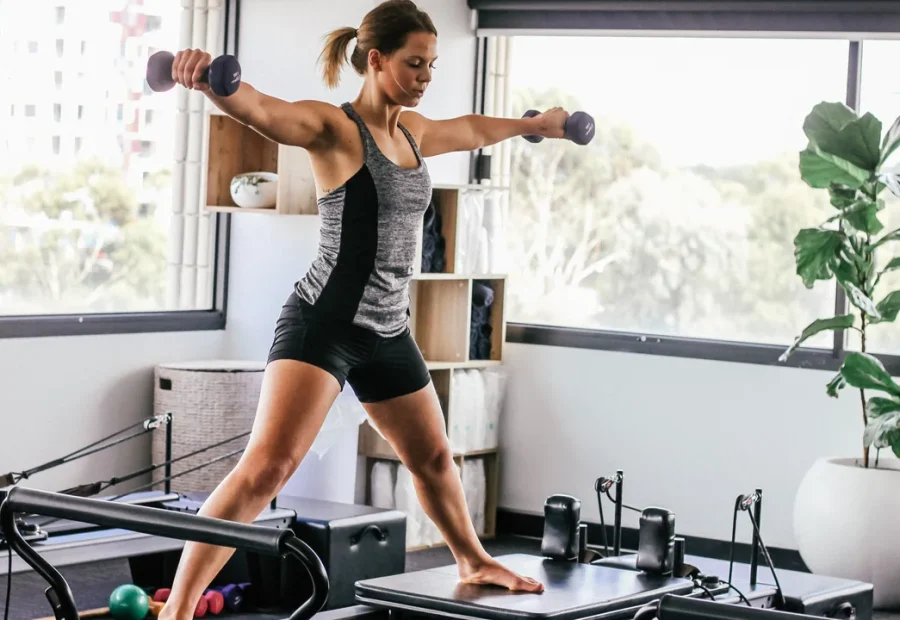 Mulher praticando Pilates no Reformer em um estúdio