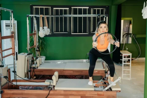 Mulher praticando Pilates no Reformer em um estúdio