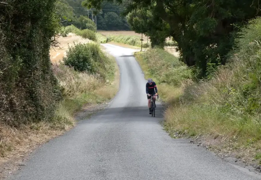 Ciclista subindo uma estrada rural