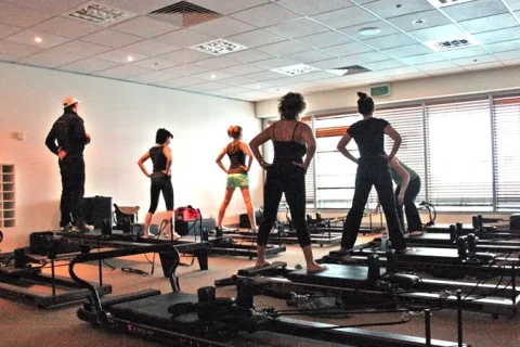Aula de Pilates com aparelhos Reformer em um estúdio