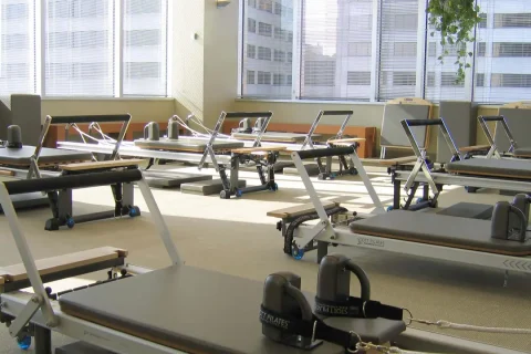 Estúdio de Pilates com aparelhos Reformer organizados para aulas.