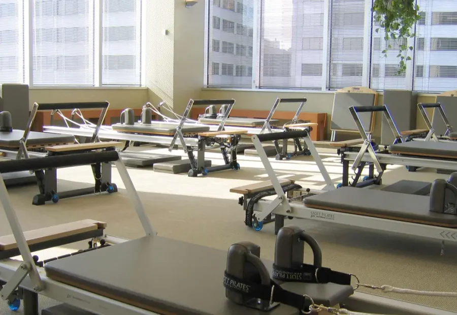Estúdio de Pilates com aparelhos Reformer organizados para aulas.