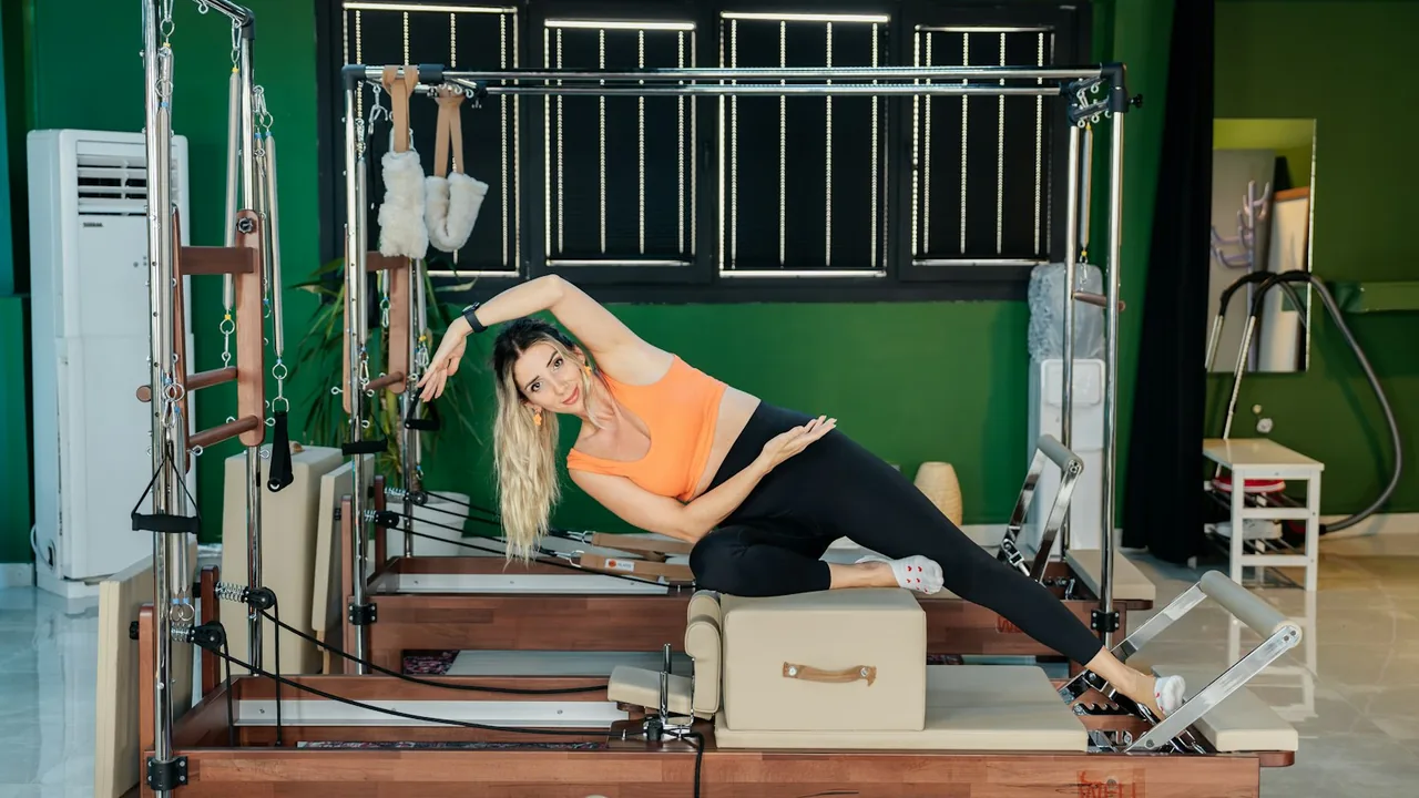 Aluna realizando exercício em um Reformer dentro de um estúdio de Pilates