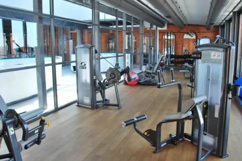 Academia de hotel com aparelhos de exercício e espaço para movimento