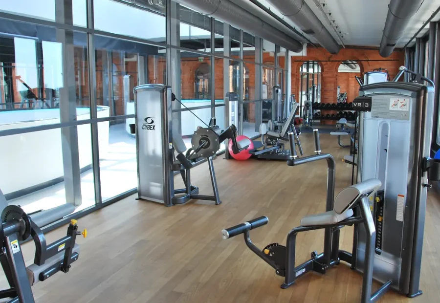Academia de hotel com aparelhos de exercício e espaço para movimento