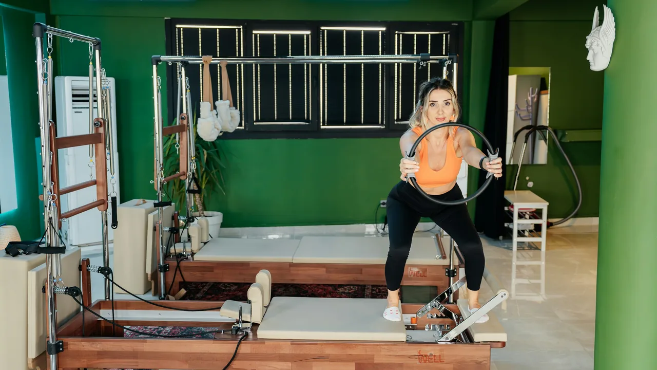Aluna em aparelho de Pilates em um estúdio