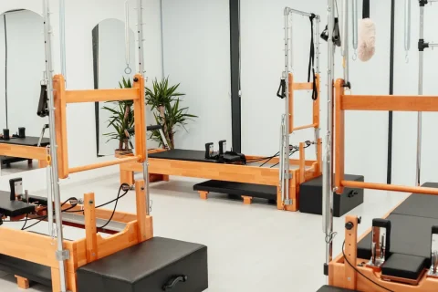 Estúdio de Pilates com aparelhos de madeira e torre